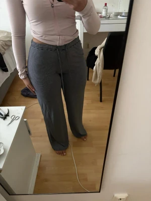 Randiga vida pyjamasbyxor med dragsko - Mysiga pyjamasbyxor med smala svarta och vita ränder, vida ben och dragsko i midjan. Perfekta för chill dagar hemma. Mjukt och stretchigt material som sitter skönt på kroppen. Felfria nypris 150kr!