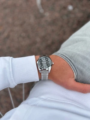 Silverfärgad svart klocka x Doventi  - 🌟 Doventi - Helt ny och oanvänd klocka i toppskick! 🌟 🎁 Levereras komplett med originalbox. ✨ Perfekt skick, garanterat utan defekter. ⚙️ Enkel justering för optimal passform. 🚀 Snabb leverans samma dag – direkt till dig!