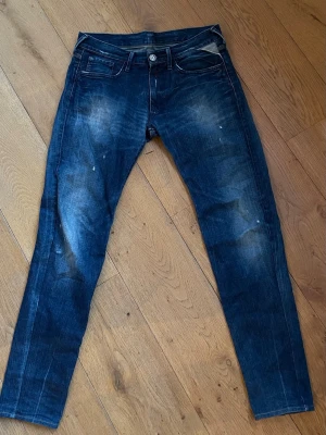 Mörkblå slim fit jeans med slitningar - Snygga mörkblå slim fit jeans med slitna detaljer och ljusa partier på låren. Äldre modell men sjukt sköna och bekväma.