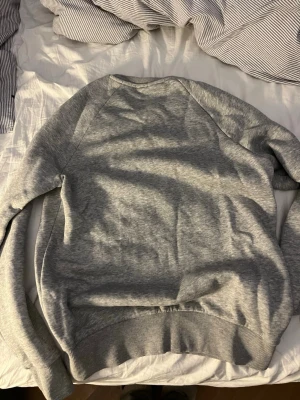 Grå sweatshirt från Peak Performance - Säljer en stilren grå sweatshirt från Peak Performance. Tröjan har rund halsringning, ribbade muddar vid ärmslut och nederkant samt diskret logga på bröstet.