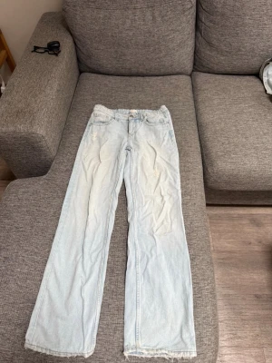 Ljusblå raka jeans med rå kant - Säljer ett par ljusblå jeans med raka ben och råa kanter nertill. Jeansen har klassisk femficksdesign och är i en avslappnad passform. De är från Gina Tricot Young i storlek 152. Har lagt ut två par likadana då jag har 2 stycken.