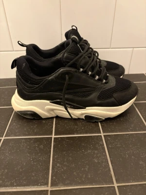 Dior b22 - Säljer ett par svarta b22 i storlek 42. Skorna är i bra skick men har lagningar vid hälen, Inget som syns vid användning. Skriv vid intresse!