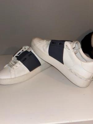 Valentino open Navy blue - Snygga vita sneakers från Valentino näst intil helt oanvända. Skorna är i läder och har en stilren, modern design utan synliga snören. Perfekta för dig som gillar exklusiva och trendiga skor. Skriv privat för pris. Eller fler bilder 