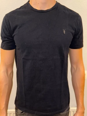 Svart t-shirt från Allsaints - En stilren svart t-shirt 