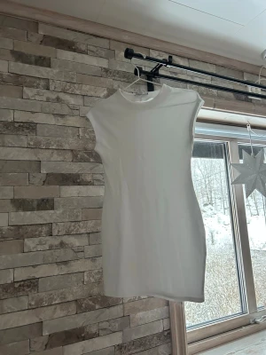 Vit kortärmad klänning från Zara - Enkel och stilren vit kortklänning från Zara med rund hals och korta ärmar. Klänningen har en rak passform och är gjord i mjuk bomull, perfekt för en clean och fräsch look.