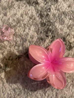 Hårklämmor  - Bilderna visar två rosa hårklämmor i form av blommor, en stor och en liten blommig hårklämma. 