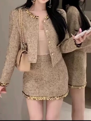 Set 2st jacka och kjol  - Säljer en beige kavaj i ullmix med guldiga paljettdetaljer längs krage, ärmslut och nederkant. Jackan har rundad hals, dekorativa knappar framtill och en croppad passform. Perfekt för dig som vill ha en chic och trendig look.