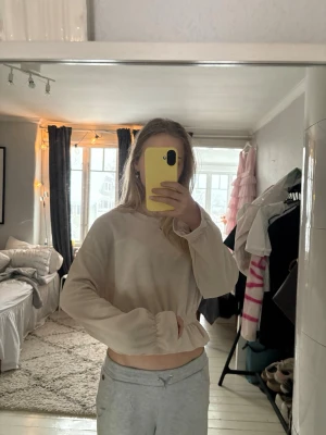 Beige croppad långärmad topp - Säljer en beige croppad topp med långa ärmar och resår i midjan.