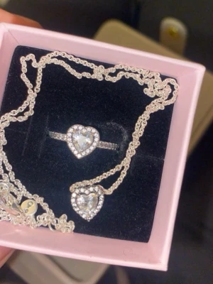 Pandora halsband med hjärthänge - Säljer ett äkta Pandora halsband i silver med ett gnistrande hjärthänge täckt av små stenar. Fick den från mitt ex därför säljer jag den!