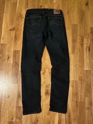 Mörkblå Lee jeans straight fit - Säljer ett par mörkblå jeans från lee det är ett riktigt fint par jeans med en väldigt bra passform jag köpte dem för en månad sedan ungefär då låg dem på 1100kr storlek w30 l32 dem är iprinsip nya eftersom dem var försmå och bara har legat i min låda ett tag
