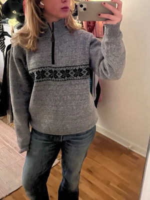 Stickad half zip tröja - Stickad half zip tröja, materialet är i stickat/fleece. Produkten är grå och har ett mönster med snöflingor på sig. Står att storleken är xl, men den passar någon med M/L. 💋