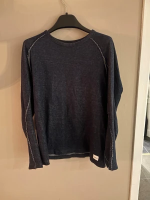 Mörkblå långärmad tröja från Dondup - Säljer en mörkblå långärmad tröja från Dondup med synliga kontrastsömmar och rund hals. Tröjan har en avslappnad passform och är tillverkad i mjukt material, perfekt för lager på lager under höst och vinter. Är storlek XL men sitter som en M. Hör av dig vid någon fråga. Pris kan diskuteras