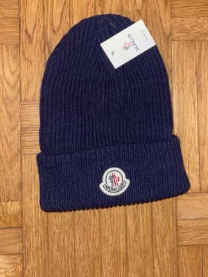Moncler mössa - Riktigt fin Moncler mössa. Bra pris, helt ny, inte mycket och säga. Påse följer med.