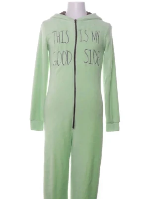 Grön Baby Yoda byxdress med huva - Säljer en ljusgrön byxdress inspirerad av Baby Yoda från The Mandalorian. Huvan har stora ögon och öron som liknar Grogu. Dragkedja framtill och texten 'This is my good side' på bröstet. Mysigt material, perfekt för chill dagar.