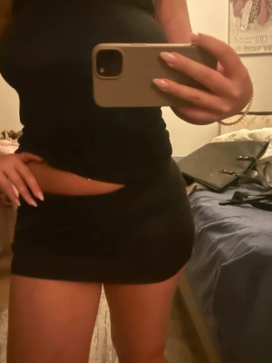 svart tight minikjol - Säljer en svart tight minikjol med enkel design. Kjolen är kort och sitter figurnära, perfekt för dig som gillar en clean och stilren look. Materialet känns mjukt och stretchigt, vilket gör den bekväm att bära. Passar till många olika outfits.