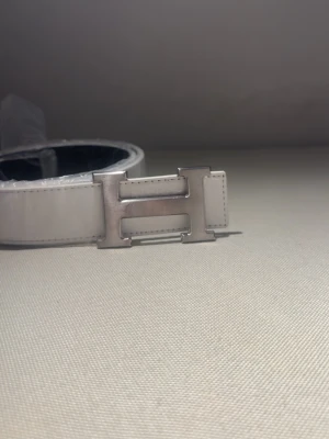 Vit Bälte med H-format spänne – no brand - ✨ Nytt bälte! ✨ 	•	Längd: 110 cm 	•	Finns i vitt & svart ⚪⚫ 	•	Stilrent och praktiskt för alla tillfällen 👌  💖 Köp fler – spara mer! 	•	2 stycken eller fler → rabatt gäller! 🎉