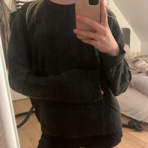 Svart stickad tröja från Uniq Studio - Mysig svart stickad tröja från Uniq Studio med rund halsringning och långa ärmar. Tröjan har en loose passform och är perfekt för lager-på-lager under kyliga dagar. Enkel och stilren design som funkar till allt.