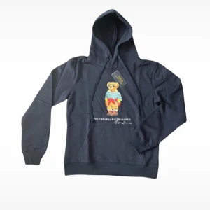 Ralph Lauren hoodie  - Ralph Lauren Teddy bear hoodie. Den är helt nya med prislapparna och allt kvar. Säljes då den blev för liten för mig och möjligheten till att lämna tillbaka inte finns eftersom det var en gåva och kvitto saknas. Axelbredd 46,5cm, längd 62cm. Bara att skriva vid frågor :) 