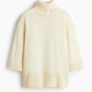 Beige polotröja med vida ärmar - Supermjuk beige polotröja med bred ribbad krage och detaljer vid ärmslut och nederkant som är slutsåld xxs-m. Tröjan har en loose passform och trekvartsärmar som ger en chill och modern vibe. Perfekt att styla med både jeans och kostymbyxor. Helt ny med lappen kvar.