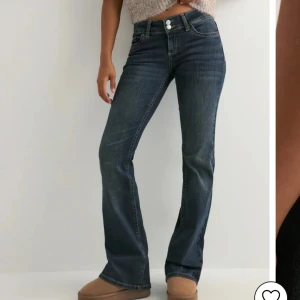 Mörkblå bootcut jeans med broderade fickor - Snygga mörkblå jeans med bootcut passform och klassisk femficksdesign. Jeansen har broderade bakfickor med gul tråd och dubbla knappar i midjan. Nypris är 699, använda fåtal gånger 