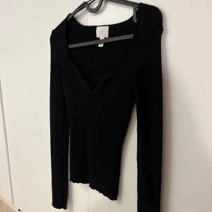 Svart ribbad långärmad topp H&M - Svart långärmad topp från H&M, ribbad struktur v-ringad halsringning. 