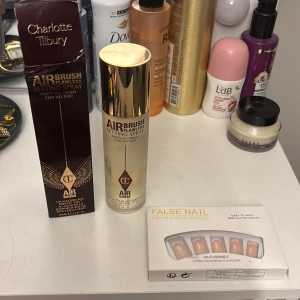Charlotte Tilbury Airbrush Setting Spray - Charlotte Tilbury Airbrush Flawless Setting Spray i lyxig guldig flaska, 100 ml. Ger en flawless finish och håller sminket på plats hela dagen. Perfekt för att fixera din makeup och ge en fräsch look. Kommer med originalförpackning. Naglarna ingår gratis!