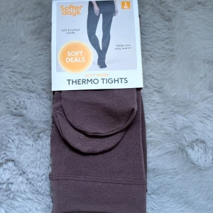 Bruna termo-tights från Softer Days XL - Mysiga termo-tights i brun färg från Softer Days, storlek XL. De är tillverkade i mjuk polyesterblandning med borstad insida för extra värme. Perfekta för kalla dagar när du vill hålla dig varm och bekväm.