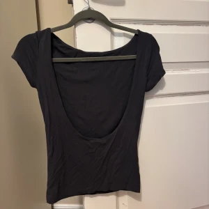 Tröja med öppen rygg - Säljer denna mörkgrå tröjan med öppen rygg!☺️☺️