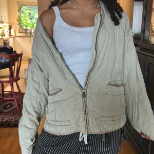 Beige quiltad jacka från Zara XS - Quiltad beige jacka från Zara i storlek XS. Jackan har dragkedja framtill, två fickor med lock och dragsko i nederkant. Oversized passform och vågiga sömmar som ger en cool look. Perfekt för lager-på-lager och chillare dagar.