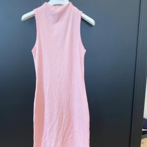 Rosa ribbad klänning från Pull&Bear - Säljer en ljusrosa, ärmlös och ribbad klänning från Pull&Bear i storlek XS. 