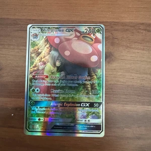 Vileplume GX - Cool och glittrig Pokémon GX-kort med Vileplume! Perfekt för samlare och Pokémon-fans som vill boosta sin lek med en stark och unik karaktär. Kortet har snygg design och är ett måste för dig som älskar Pokémon.