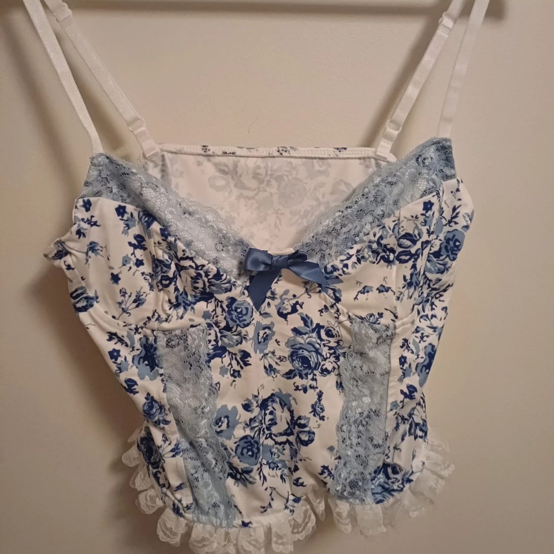 Blommig topp med spets och rosett