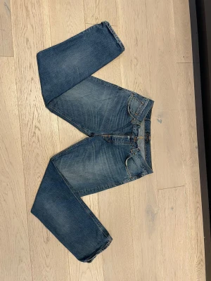 Nudie Jeans, W36/L34 - Nudie Jeans i ganska bra skick, liten defekt i toppen av gylfen som inte märks när man har t.ex: En tröja över. Modellen är 183cm lång och byxorna är storlek W36/L34