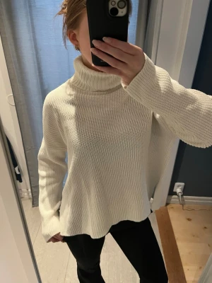 Vit stickad polotröja med loose fit - Säljer en vit stickad polotröja med bred krage och långärmad modell. Tröjan har en loose passform och är ribbad i strukturen