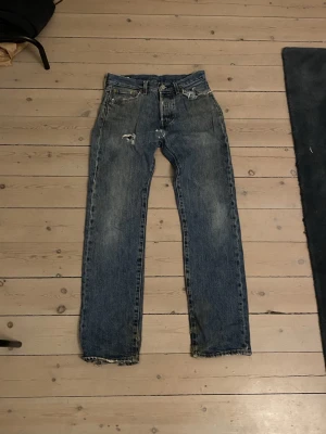 Levi's 501 blå jeans W28 L32 - Klassiska Levi's 501 jeans i blå tvätt med antal defekter lite hål runt om ( fråga för bilder) de tvättas innan de skickas !!  Ny Priss  1200kr vårt pris 99kr