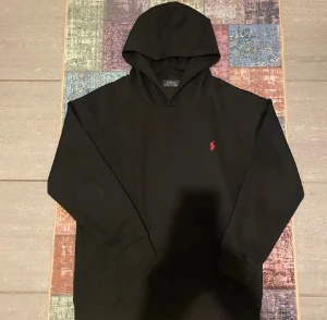 en svart hoodie ralph lauren - det står att den är i L men jag skulle säga att den passar mer s elle m 