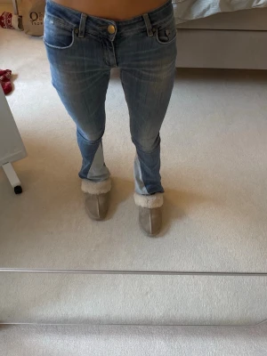 Dondup blå jeans bootcut låg midja - Säljer ett par klassiska blå jeans från Dondup med låg midja och bootcut. Jeansen har snygg slitning, femficksmodell och råa kanter vid benslut. passformen är normal med lätt utsvängda ben. Utsydda till bootcut själv med maskin 🥰