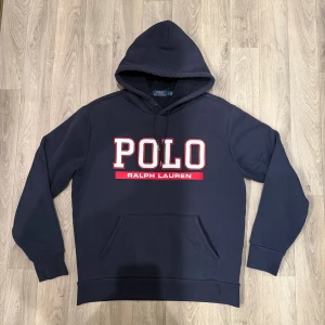 Polo Ralph Lauren Fleece Hoodie Navy M - Sjukt snygg och varm mörkblå Polo Ralph Lauren Fleece-Lined Double-Knit Hoodie i mycket fint skick. Perfekt nu till vintern när det är kallt ute. Storlek: M. Hör av dig vid frågor eller funderingar!😊