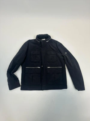 J.Lindberg jacka/field jacket/overshirt  - Tjena! Säljer denna sjukt snygga och eftertraktade J.Lindeberg field jacket! Jackan är slutsåld nästan överallt och går inte att få tag på… Jackan är även helt perfekt nu till vinter! Storlek L, Ny pris: 6000kr, vårt pris 1299!