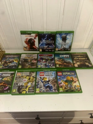 Xbox One Spelpaket (12 spel) - Paket med 12 Xbox One-spel, inklusive Star Wars Battlefront, Rocket League, FIFA 17, LEGO Worlds, Dirt Rally och fler. Skivorna och fodralen ser ut att vara i gott skick. Perfekt för familjer eller samlare som vill utöka sitt spelbibliotek.