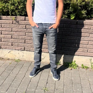 Gråa Jack and Jones jeans  - Säljer ett par svin snygga gråa jeans! Killen på bilden är 182 cm. Nyskick! 