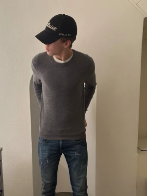 Grå merinoulltröja These Glory Days - Säljer en stilren grå tröja från These Glory Days i mjuk merinoull. Klassisk rund halsringning och långärmad modell med normal passform. Perfekt till jeans eller chinos för en clean look.  Original pris ca 1000 kr