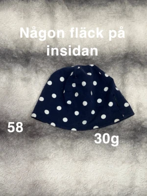 Mörkblå prickig mössa från Polarn o pyret - Snygg mörkblå mössa med vita prickar, perfekt för att ge din outfit lite extra stil. Mjuk och skön passform, enkel att bära både till vardags och när du vill sticka ut lite. Storlek 58🌸Någon fläck på insidan. 