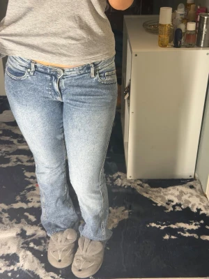 Lågmidjade Ljusblå bootcut jeans med broderade fickor - Lågmidjade  jeans från Gina. Princip helt nya