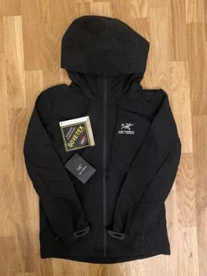 Arc'teryx windbreaker  - Svart windbreaker från Arc'teryx. Jackan är tillverkad i Gore-Tex polyester. Perfekt för blåsiga dagar och outdoor-äventyr. Storleken på jackan är M, men den passar xs/s pga att jackan är kort om armarna,