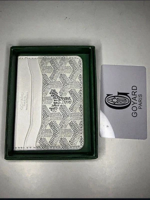 Vit plånbok med unik design - Säljer en stilren vit plånbok med ikoniskt geometriskt mönster och flera kortfack. Plånboken är tillverkad i exklusivt skinn. Perfekt för dig som vill ha något lyxigt och unikt i fickan.