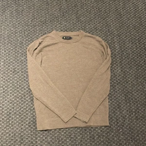 Beige merinoulltröja från Riley - Säljer en stilren beige tröja från Riley i 100% merinoull. Perfekt för kyligare dagar med sin mjuka och bekväma känsla. Tröjan har långa ärmar och en klassisk passform. Ett måste i garderoben för den som gillar kvalitet och stil. Storlek S! Skriv vid funderingar🤩
