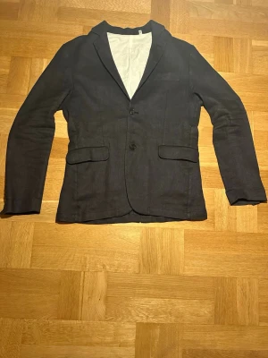 Mörkblå vardags kavaj från our legacy  - Jag säljer min sjukt snygga our legacy kavaj nu eftersom jag tyvärr växt ur den. Kavajen är mörkblå i ett mycket kvalitativt tyg. Jag skulle säga att det är en 9/10 gällande skick och man ser knappt spår av användning. I nypris kostar en sån här kavaj mellan 6000-7000 kr, därav ett lite dyrare utgångspris men det är såklart förhandlingsbart. 