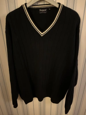 Mörkblå stickad tröja - Mörkblå stickad tröja från Request, exklusivt för Kappahl, i storlek L. Tröjan har ribbad struktur och en v-ringad hals med vita ränder som detalj. Långärmad och klassisk modell som är både snygg och enkel att matcha.