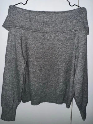 Grå offshoulder stickad tröja H&M - Säljer en grå stickad tröja från H&M i storlek S. Tröjan har en bred offshoulder-krage och långa ärmar, perfekt för kyliga dagar. Mjuk och skön kvalitet som ger en avslappnad och snygg look.
